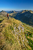 Frau beim Wandern blickt ins Tal, Salzkammergutberge im Hintergrund, vom Hochwieskopf, Salzkammergut, Salzburg, Österreich