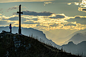 Frau beim Wandern steht am Gipfel des Hochgern und blickt aufs Tal, Hochgern, Chiemgauer Alpen, Oberbayern, Bayern, Deutschland