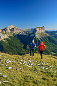 A man and a woman to climb up to the Tête Chevalier, Grand Veymont and Mont Aiguille in the background, Tête Chevalier, Vercors, Dauphine, Dauphine, Isère, France