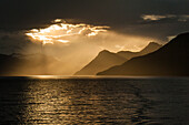 Sun breaks through cloud-cover off the Chilean coast, Beagle Canal, Alberto de Agostini National Park, Magallanes y de la Antartica Chilena, Patagonia, Chile, South America