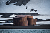 Riesige Lagertanks stellen ein altmodisches Gebäude im Hintergrund dar und zeugen von der Geschichte des Walfangs, Deception Island, Südliche Shetlandinseln, Antarktis