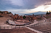Blick auf das Teatro Antico di Taormina im Sonnenuntergang mit Meer und Ätna im Hintergrund, Taormina, Sizilien, Süditalien, Italien