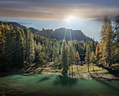 See und Kiefernwald bei Sonnenaufgang in den Dolomiten, Südtirol, Italien
