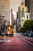 A cable car on California street, with financial district on the background, San Francisco, California, United States Of America