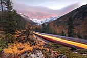 Bernina Express train along the colorful woods in autumn, Morteratsch, Engadine, canton of Graubunden, Switzerland