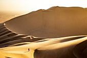 Man walking on the sand dunes at sunset,Walvis Bay,Namibia,Africa