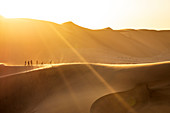 Leute bei Sonnenuntergang auf Sanddüne, Walfischbucht, Namibia, Afrika gehen