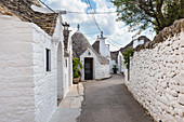 View of the typical Trulli huts and the alleys of the old village of Alberobello. Province of Bari, Apulia, Italy, Europe.