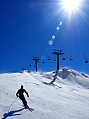 Skifahrer und Sessellift im Skigebiet Weißsee über dem Enzingerboden in den Hohen Tauern, Pinzgau, Österreich