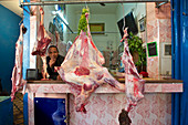 Verkäufer in Fleischerei mit geschlachteten Tieren, Ziege und Rind, auf dem Markt in Rissani, Tafilalet, Marokko