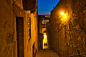 Two people late in the evening in an alley from the Cais da Ribeira to the cathedral, Porto, Portugal