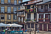 Restaurants and people on the square Praca do Santiago with typical houses, Guimarães, Minho, Portugal