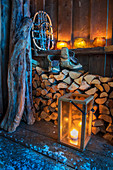 Brennholz, Laterne, Wanderschuhe und alte Schneeschuhe als Stillleben vor Eingang, Norwegen