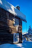 Eingeschneites Holzhaus bei Heggenes im Winter, Norwegen