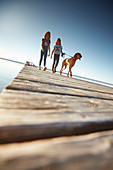 Zwei zehnjährige Mädchen mit Hund auf einem Steg,   Starnberger See, Bayern, Deutschland
