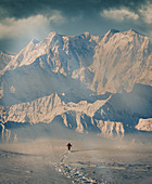 Man hiking through snow by mountain in Alpe Devero, Italy
