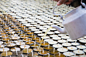 Butter is filled into traditional Buddhism butter lamps in Kathmandu, Nepal.