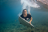 Männlicher Surfer, der Kamera beim Tauchen im Ozean, Male, Malediven