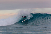Male surfer riding wave against sky, Male, Maldives