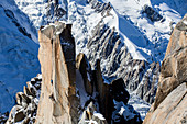 Two alpinists climbing rock pillar below Aiguille du Midi in French Alps, Chamonix Mont-Blanc, Haute Savoie, France