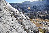 Backpackers scramble their way to Bighorn Pass above Laurel Lake, California, USA