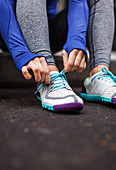 Surface view of woman tying shoelaces before going for evening run, Seattle, Washington, USA