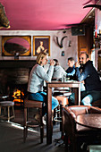 Customers sitting and drinking at table in restaurant, Portree, Isle of Skye, Scotland, UK