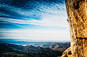 Junge Frau klettert auf die Klippe, Magaluf, Katalonien, Spanien