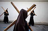 Hooded penitents carry crosses during Easter Week celebrations in Baeza, Jaen Province, Andalusia, Spain