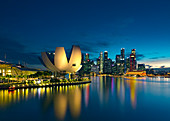 Wolkenkratzer und beleuchtetes Gebäude von Art Science Museum nachts, Singapur