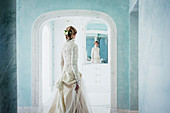 Elegant bride in lace wedding dress at mirror