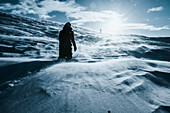 Mann in schneebedeckter Landschaft, Reykjadalur, Island