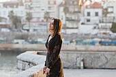 Serene female tourist standing at waters edge, Cascais, Lisbon, Portugal