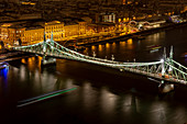 View of the Budapest Liberty Bridge at night with the ships on the Danube