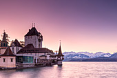 Sunrise at the castle of Oberhofen am Thunersee with the snow-covered Bernese Alps, Canton of Bern, Switzerland, Europe