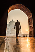 Sun rises behind the Taj Mahal as a man walks in, UNESCO World Heritage Site, Agra, Uttar Pradesh, India, Asia