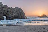 Waves washing up on rocky beach at sunset, USA