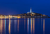 Illuminated coastal city reflected in still water, Rovinj, Istria, Croatia