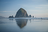 Haystack Rock reflecting in ocean, Cannon Beach, Oregon, United States