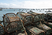 Stacked fishing baskets and fishing boats in the fishing port of Cascais, Portugal