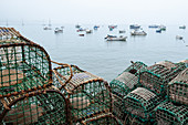 Fangkörbe und Fischerboote im Fischerhafen von Cascais bei Nebel, Portugal