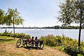 Radfahrer entspannen beim Blick über die Aussenalster in Hamburg, Norddeutschland, Deutschland