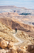 Mountainbiker unterwegs in der felsigen Wüste Negev, Israel