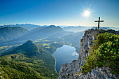 Person sitzt am Gipfel der Trisslwand, Tiefblick auf Altausseer See, Dachsteingebirge und Salzkammergut, Trisslwand, Salzkammergut, Salzburg, Österreich