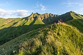 Frankreich, Puy de Dome, Regionaler Naturpark der Vulkane der Auvergne, Massiv von Sancy, Mont Dore, Wanderer auf einem Bergkamm über das Val d'Enfer, die Seilbahn des Mont Dore im Hintergrund