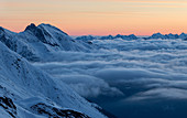 Morgenröte über winterlicher Hochgebirgslandschaft mit Wolkenmeer, Zischgeles, Sellrain, Tirol, Österreich