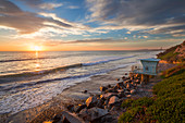 Sonnenuntergang am Strand an der Westküste Kaliforniens mit Rettungsschwimmer-Turm\n