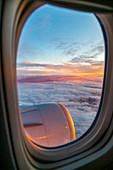 Blick aus dem Flugzeugfenster auf Sonnenaufgang über England, Großbritannien, Europa