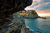 Sonnenaufgang im Dorf Manarola von einer Meereshöhle, Cinque Terre, UNESCO-Weltkulturerbe, Ligurien, Italien, Europa