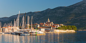 Panoramablick über Yachthafen zur Altstadt bei Sonnenaufgang, Korcula-Stadt, Korcula, Dubrovnik-Neretva, Dalmatien, Kroatien, Europa